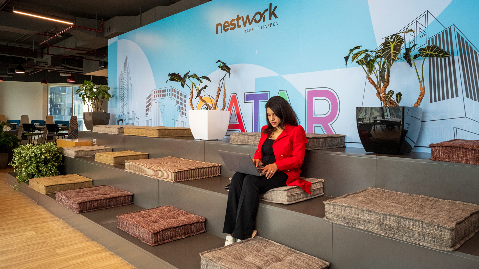 A woman using her laptop in an amphitheatre at Nestwork Coworking and Serviced Offices